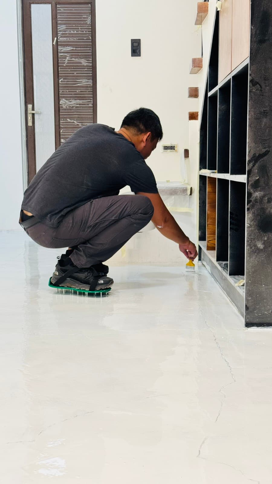 An RSN+MNL artisan hand-finishing a poured resin floor